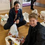 students filling bags with food for charity